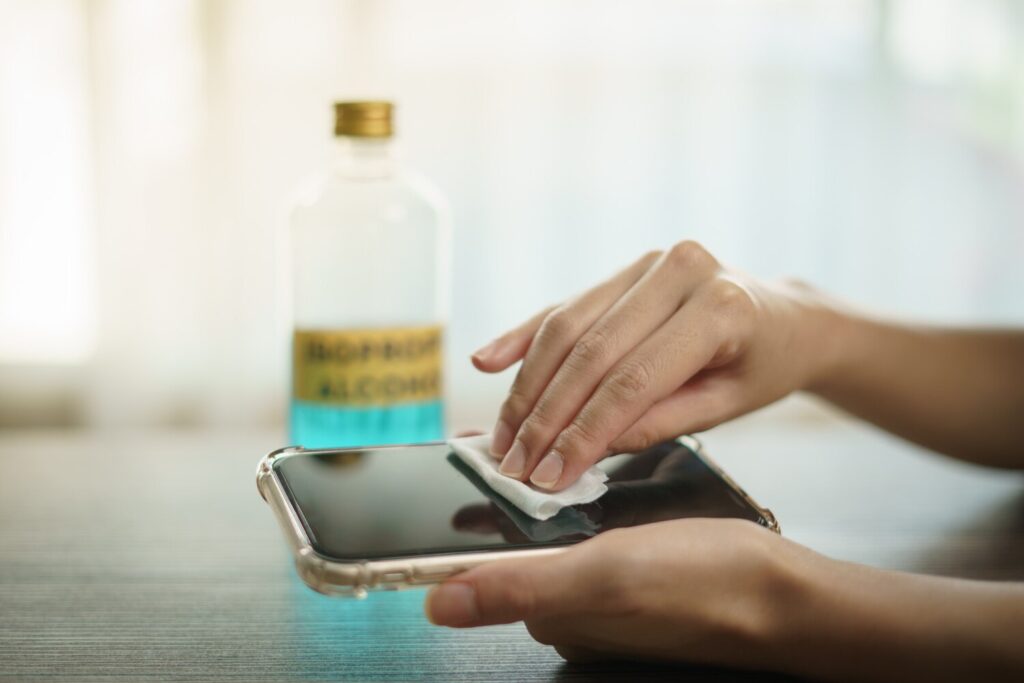 Hand pouring ethyl alcohol from bottle into cotton piece clean mobile phone corona virus covid 19 protection 46370 1388