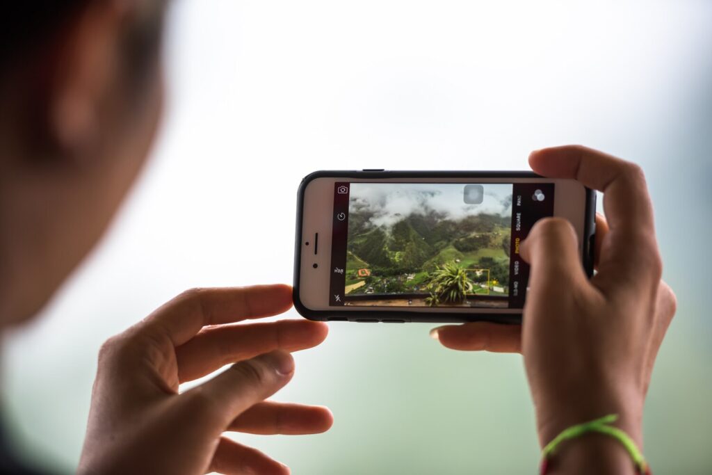 Tourist hand holding mobile phone while taking photograph landscape weekend traveling take photo by mobile phone concept 55877 602